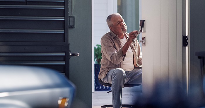 Man installing Schlage smart lock on door leading from the garage into the house.