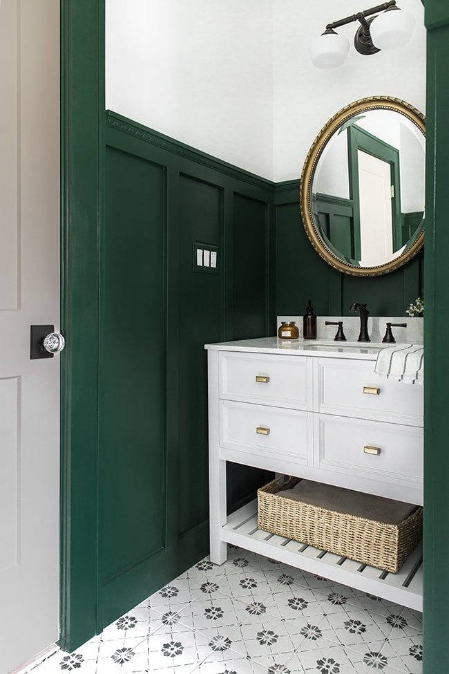 Bathroom with Matte Black door hardware and a gold mirror