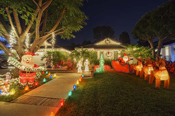 House decorated with plenty of Christmas lights and inflatables.