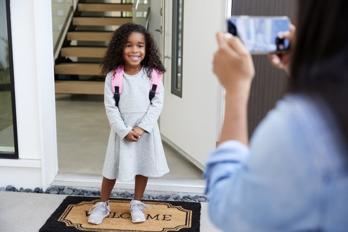 little-girl-on-first-day-of-school-by-front-door