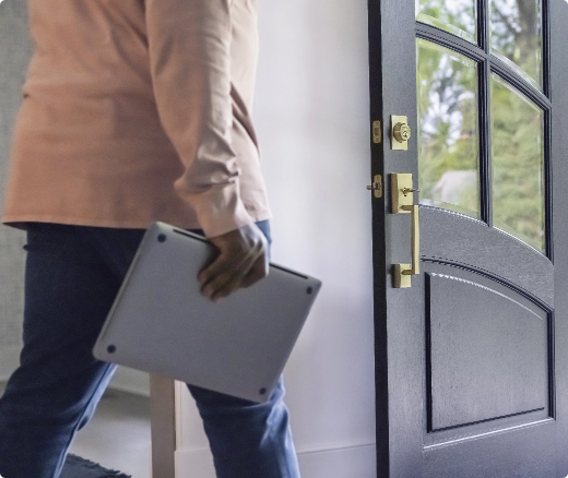 Boy walking towards the door with laptop (shop handlesets)