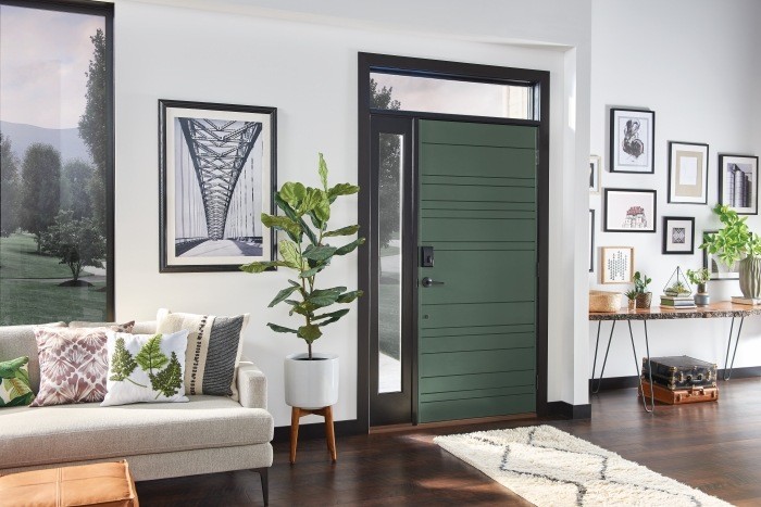 Home interior showing a green front door with a black smart lock. 